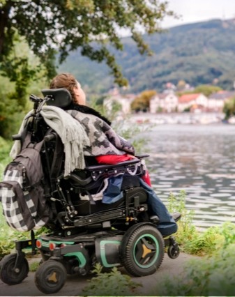 Pyörätuolissa istuva SMA-potilas katselee järvelle avautuvaa maisemaa