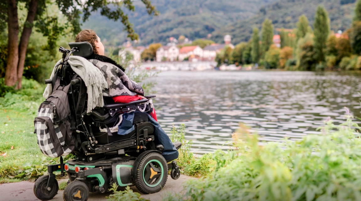 Pyörätuolissa istuva SMA-potilas katselee järvelle avautuvaa maisemaa
